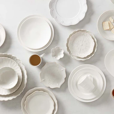 Collection of white ceramic dishes on a light gray background